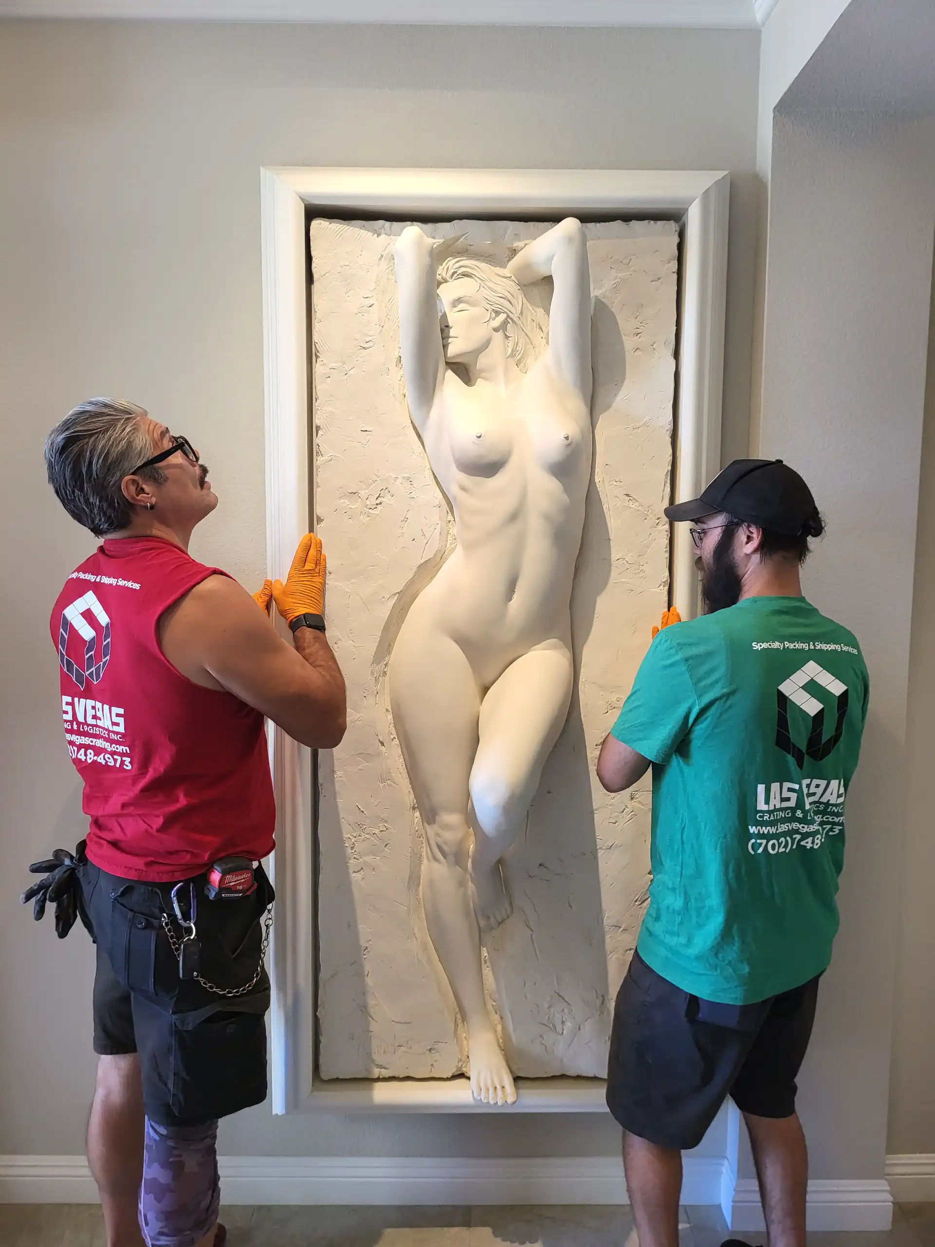 Staff installing a stone lion sculpture in a garden